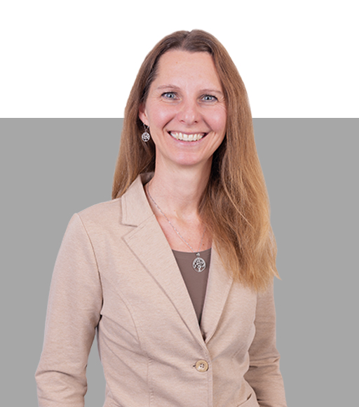 Frau mit Langen braunen Haaren lacht in die Kamera.